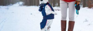 french bulldog playing outside in snow with owner